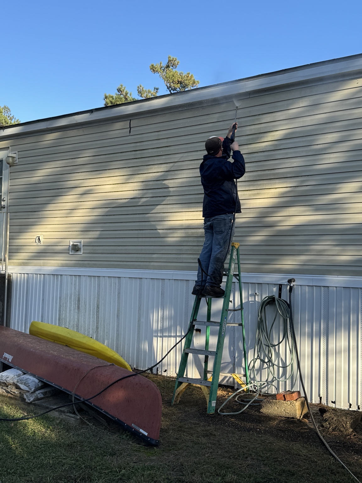 A member of our team washing exterior house siding